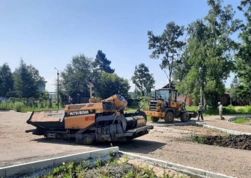 Процесс асфальтирования дорожная техника на подготовленной площадке